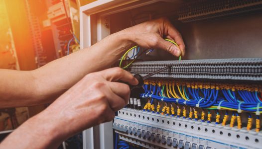 The man is repairing the switchboard voltage with automatic switches. Electrical background